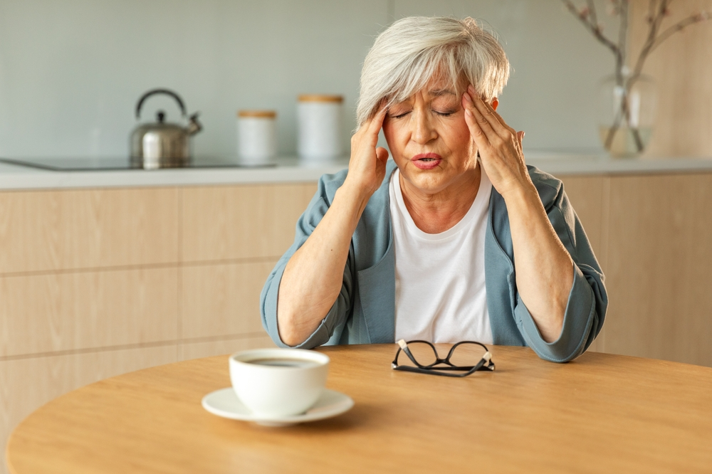 senior woman with headache holding head