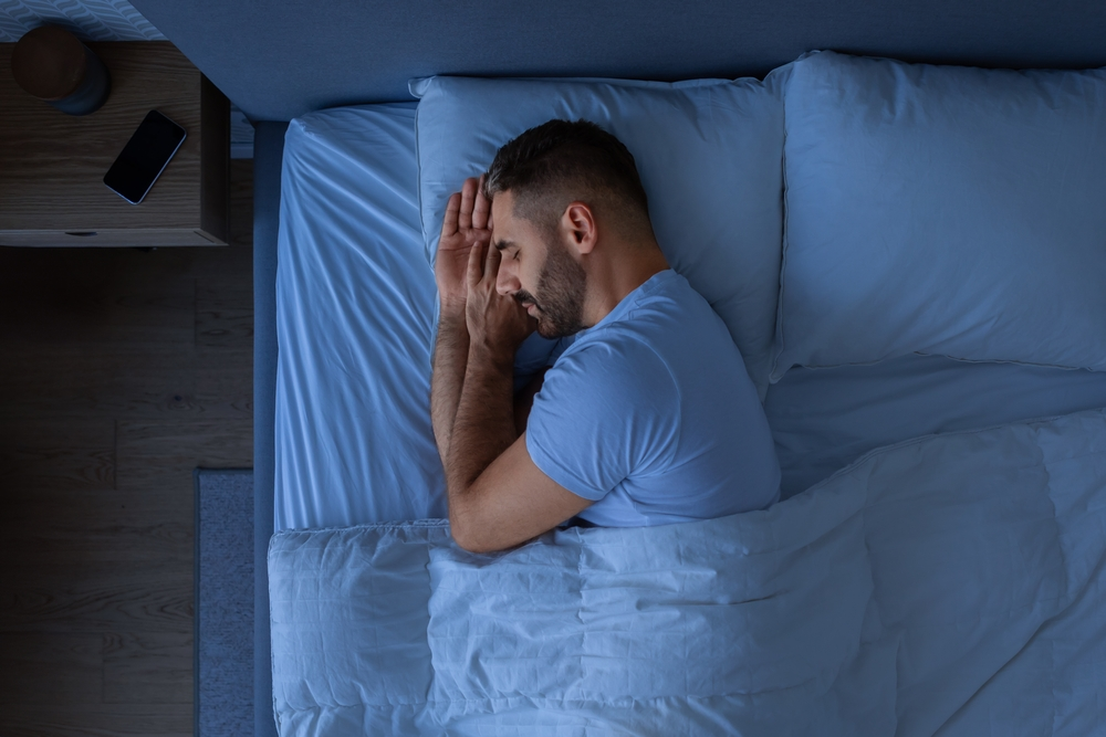 man sleeping in darkened room